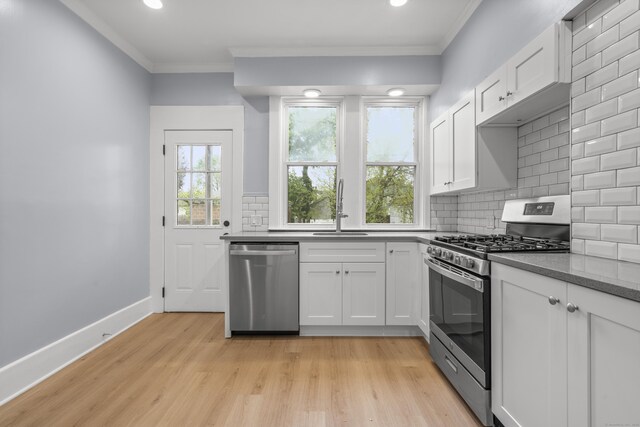669 Third Ave, West Haven, CT 06516 - kitchen featuring appliances with stainless steel finishes, a sink, ornamental molding, tasteful backsplash, and white cabinets