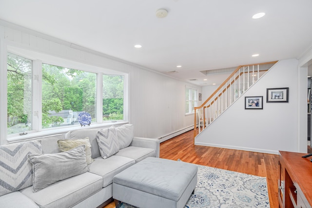 living room with stairway, light wood finished floors, a baseboard radiator, crown molding, and recessed lighting