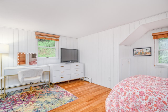bedroom featuring wood finished floors and baseboard heating