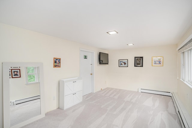 unfurnished room with a baseboard radiator and light colored carpet