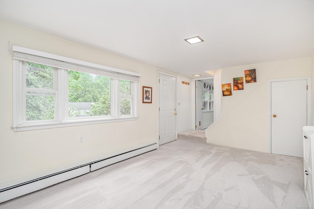 unfurnished room featuring a baseboard radiator, light carpet, and plenty of natural light
