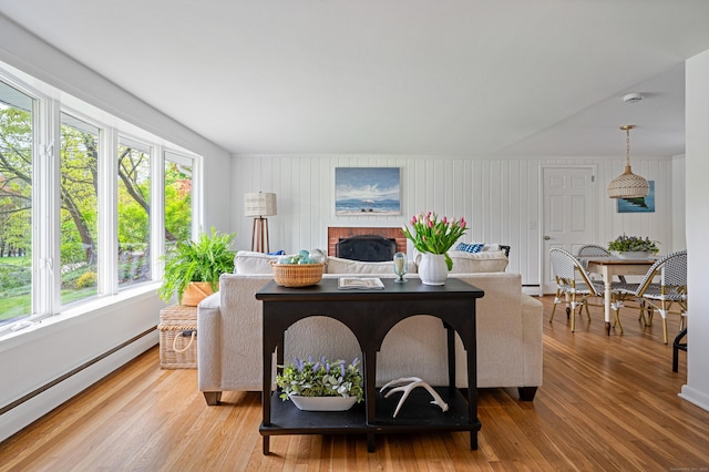 14 Arnold Ln, Norwalk, CT 06853 - living area featuring a baseboard radiator, light wood-style floors, and a brick fireplace