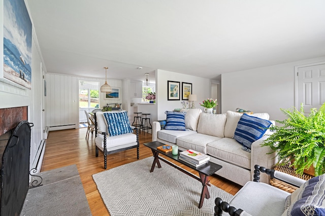 14 Arnold Ln, Norwalk, CT 06853 - living area featuring a fireplace with flush hearth, light wood-style flooring, and a baseboard heating unit