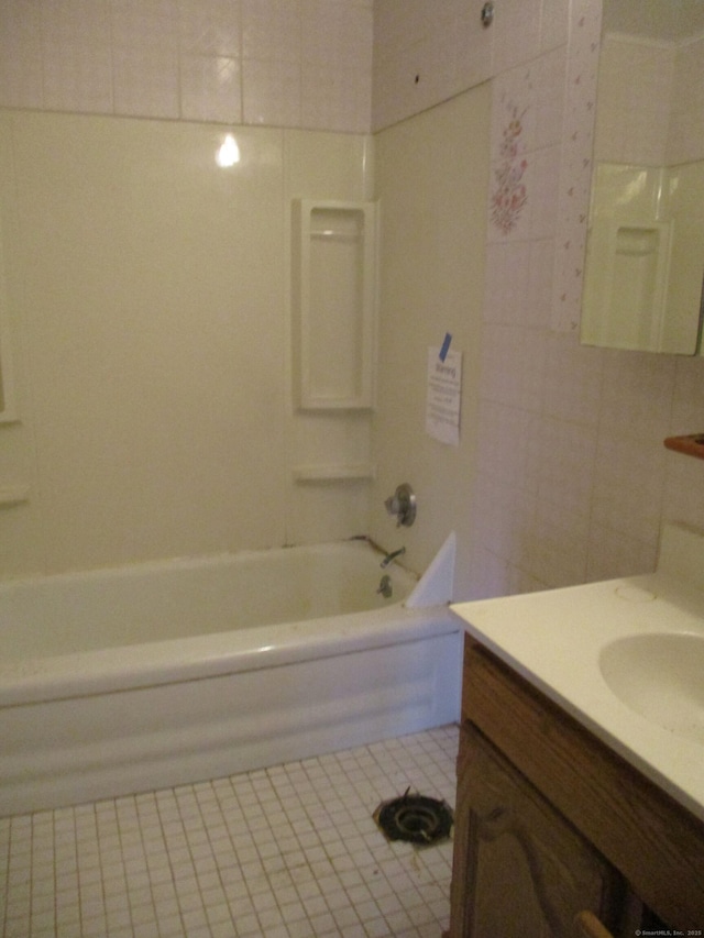 bathroom with bathtub / shower combination, vanity, and tile walls