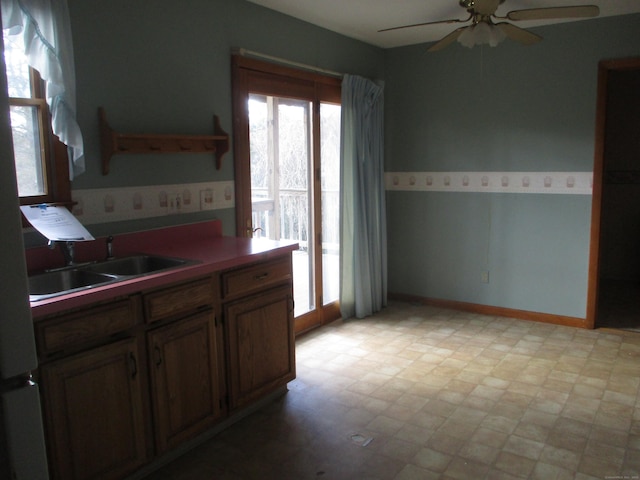 kitchen featuring ceiling fan, a sink, and light flooring
