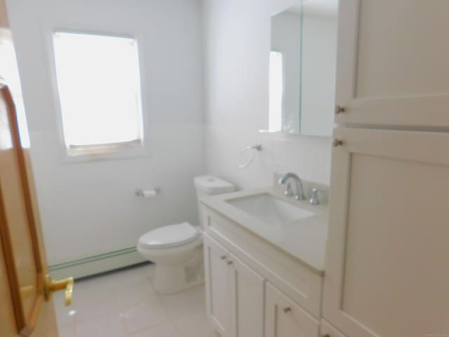 29 Barholm Ave, Stamford, CT 06907 - bathroom with a baseboard radiator, vanity, toilet, and tile patterned flooring