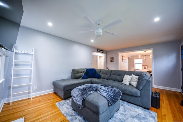 living area featuring wood finished floors, a chandelier, baseboards, recessed lighting, and a ceiling fan