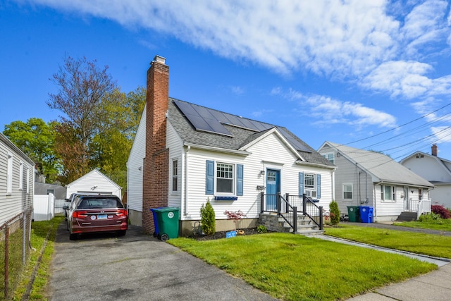 view of front of house with a chimney, solar panels, roof with shingles, and a garage