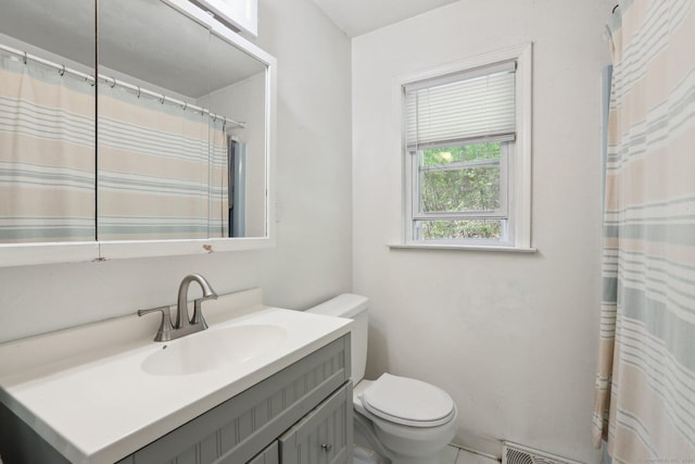 bathroom featuring toilet, vanity, and curtained shower
