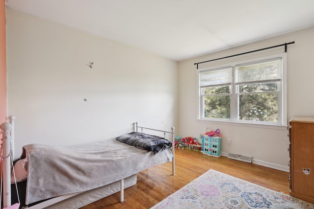 bedroom with wood finished floors and baseboards