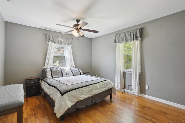 bedroom with wood finished floors, ceiling fan, and baseboards