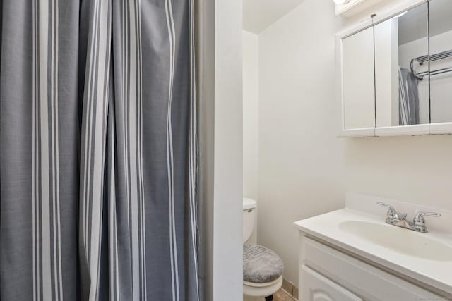 full bathroom featuring toilet, vanity, and a shower with shower curtain