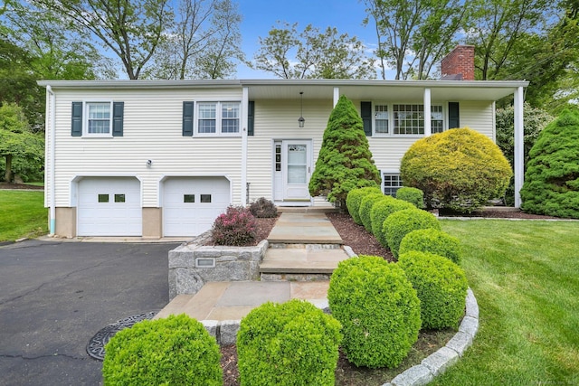 9 Cindy Ln, Norwalk, CT 06851 - split foyer home featuring a chimney, a garage, driveway, and a front yard