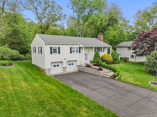 9 Cindy Ln, Norwalk, CT 06851 - bi-level home featuring a chimney, asphalt driveway, a garage, a front yard, and view of wooded area