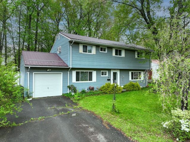colonial-style house with an attached garage, metal roof, a front lawn, and driveway