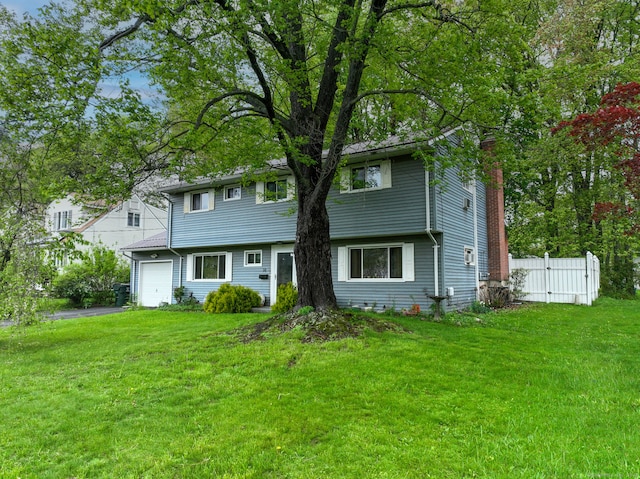 colonial inspired home with an attached garage and asphalt driveway
