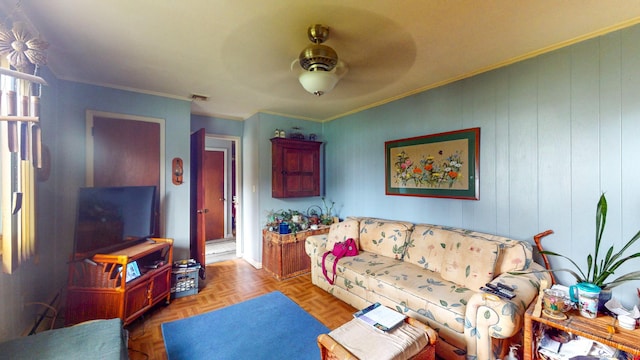 living area featuring crown molding and a ceiling fan