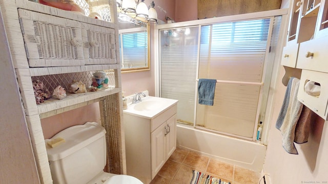 full bath with tile patterned floors, toilet, bath / shower combo with glass door, and vanity