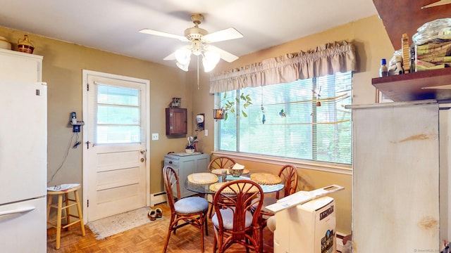 dining room featuring ceiling fan, washing machine and dryer, and a baseboard radiator
