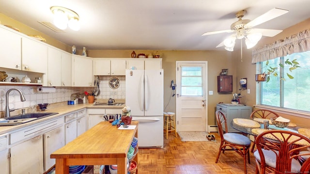 kitchen with white appliances, independent washer and dryer, a sink, light countertops, and ceiling fan
