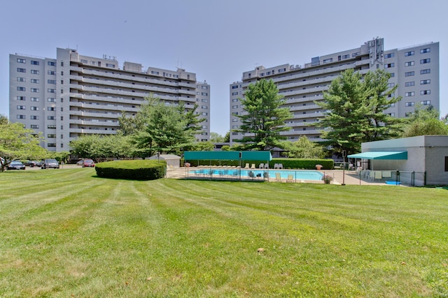 view of community with a swimming pool and a lawn