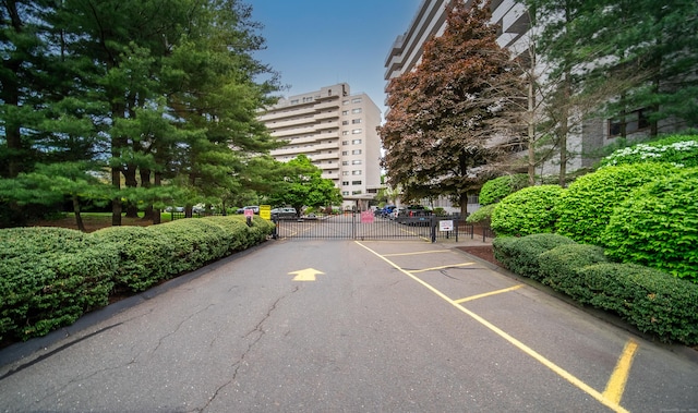 view of asphalt street featuring a gate and a gated entry