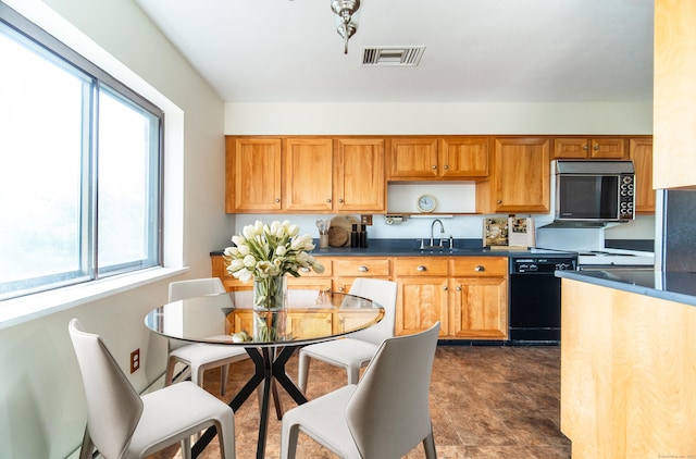 kitchen with dishwasher, a sink, dark countertops, and brown cabinets