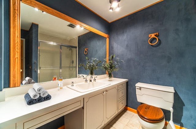bathroom featuring a shower stall, toilet, and vanity