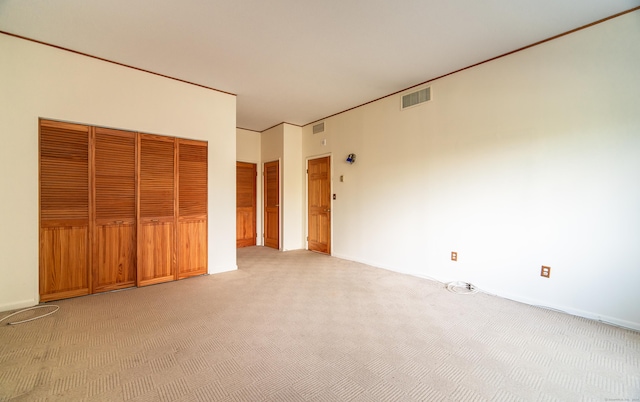 unfurnished bedroom featuring light carpet, a closet, and baseboards