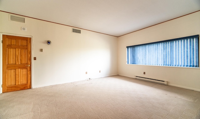 empty room with a baseboard heating unit, carpet flooring, and baseboards