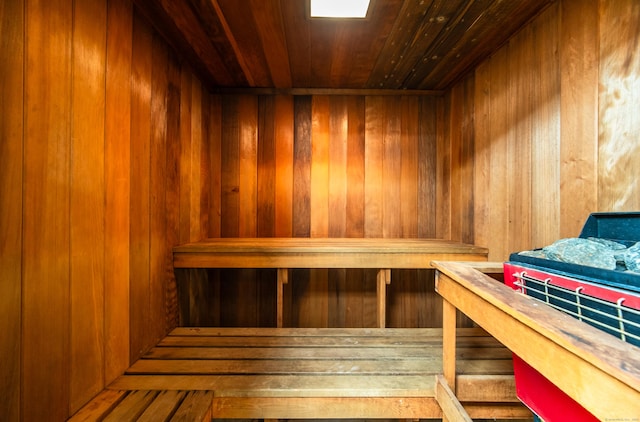 sauna / steam room with wooden ceiling and wood walls