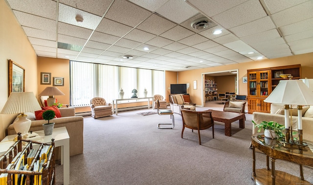 carpeted living area featuring baseboard heating and a paneled ceiling