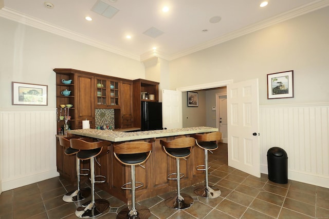 27 Country Club Rd, Ridgefield, CT 06877 - bar area featuring freestanding refrigerator, wainscoting, dark tile patterned floors, ornamental molding, and recessed lighting