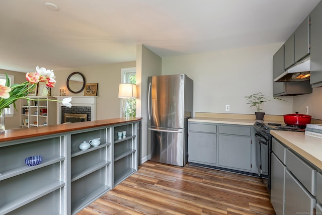 87 Canaan Rd Apt 2F, Salisbury, CT 06068 - kitchen featuring freestanding refrigerator, under cabinet range hood, gray cabinetry, black range oven, and wood finished floors