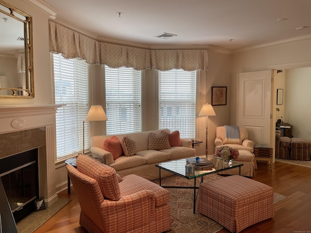 living area featuring crown molding, wood finished floors, and a premium fireplace