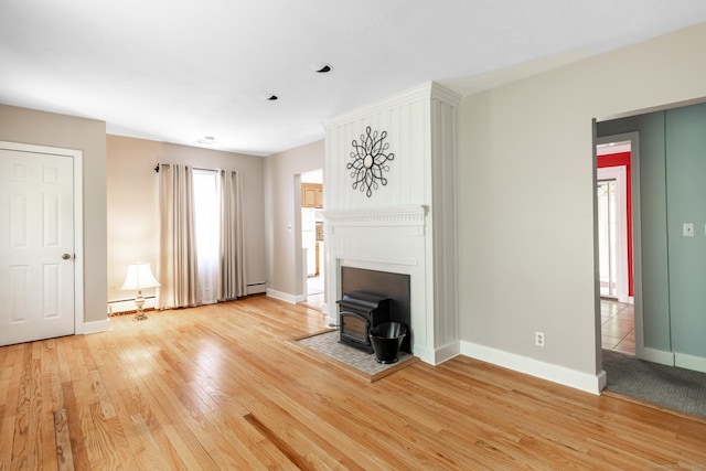 153 Mountain Rd, Cheshire, CT 06410 - unfurnished living room featuring a wood stove, light wood-type flooring, baseboards, and baseboard heating