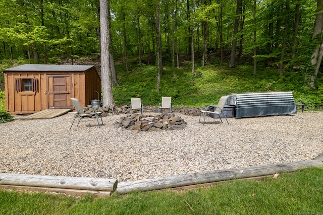 153 Mountain Rd, Cheshire, CT 06410 - view of yard featuring a storage unit, an outdoor structure, a fire pit, and a view of trees
