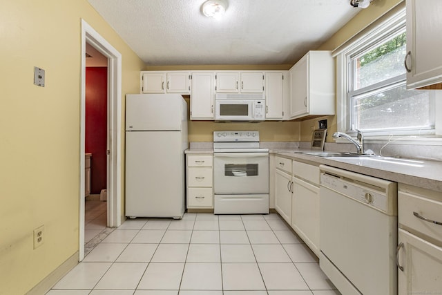 kitchen with white appliances, a sink, light countertops, white cabinetry, and a textured ceiling