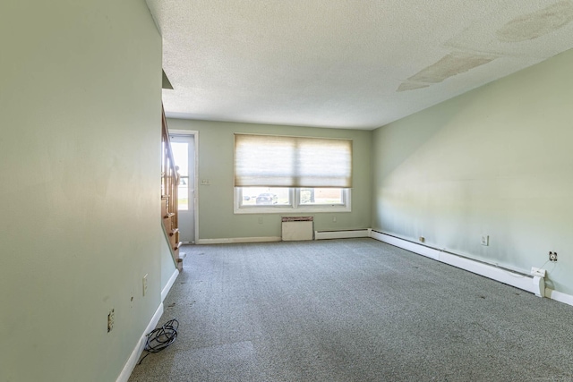 carpeted spare room featuring a textured ceiling, baseboards, and a baseboard radiator
