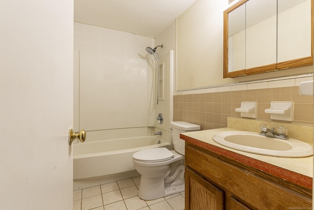 bathroom featuring toilet, tile patterned flooring, tile walls, vanity, and shower / washtub combination