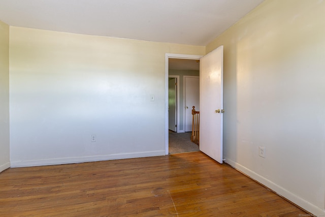 unfurnished room with wood finished floors and baseboards