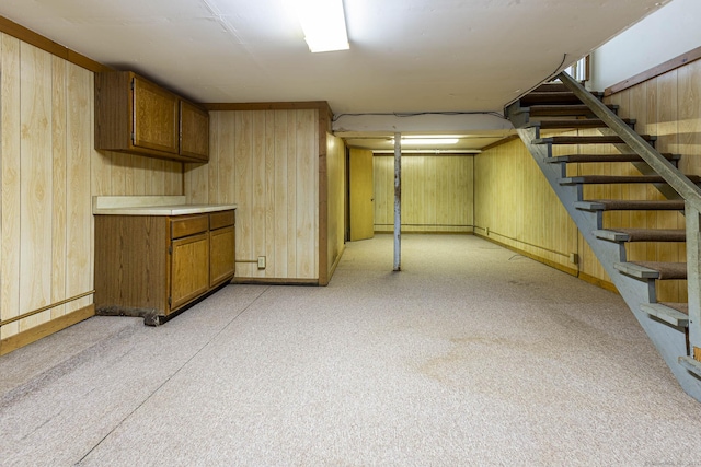 finished below grade area featuring wood walls and stairs