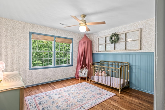 12 Rob Rider Rd, Redding, CT 06896 - bedroom featuring wallpapered walls, wood finished floors, wainscoting, multiple windows, and a nursery area