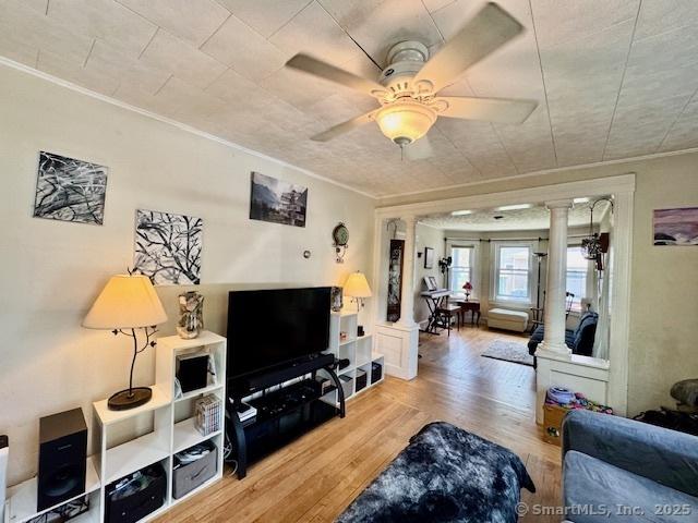 9 Addison St, Putnam, CT 06260 - living area featuring decorative columns, wood finished floors, crown molding, and a ceiling fan