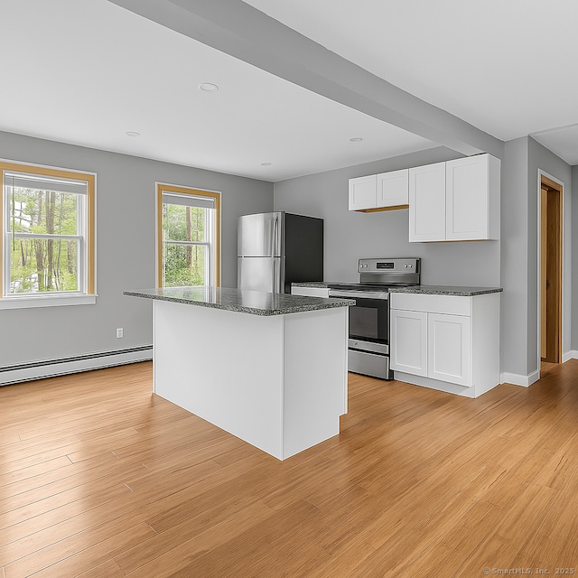 872 Nut Plains Rd, Guilford, CT 06437 - kitchen with appliances with stainless steel finishes, a baseboard radiator, white cabinetry, dark stone countertops, and a center island