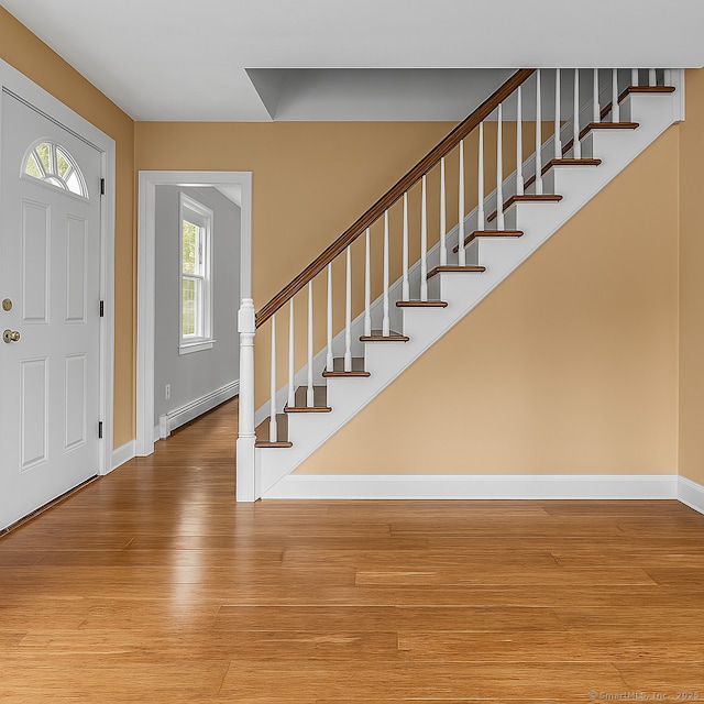 872 Nut Plains Rd, Guilford, CT 06437 - foyer with a baseboard heating unit, baseboards, wood finished floors, and stairway