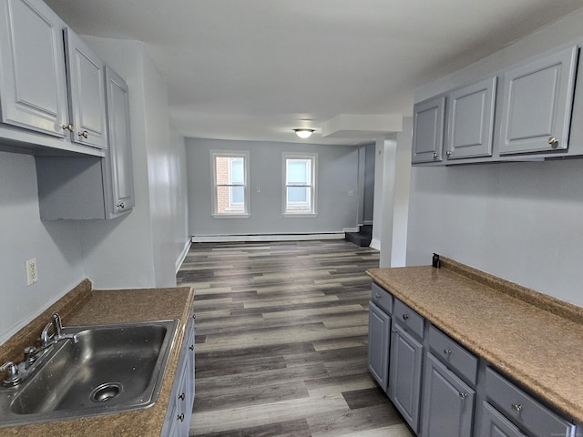 78 Tremont St, New Britain, CT 06051 - kitchen with a sink, gray cabinets, a baseboard heating unit, and dark wood-style floors