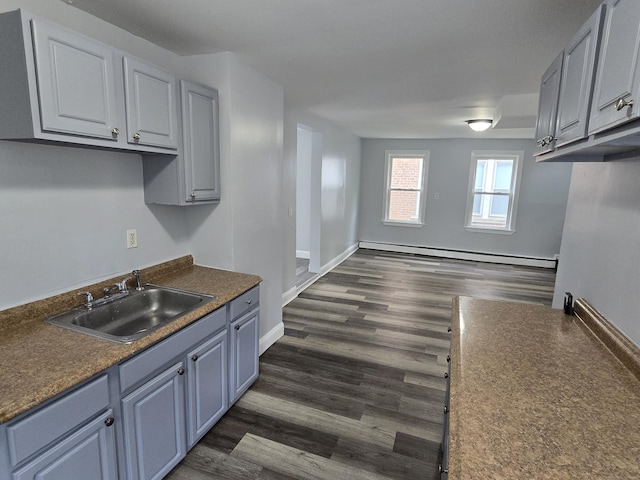 78 Tremont St, New Britain, CT 06051 - kitchen with a baseboard heating unit, a sink, dark countertops, and baseboards