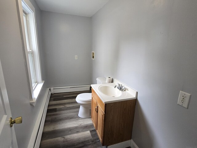 78 Tremont St, New Britain, CT 06051 - half bathroom with baseboard heating, wood finished floors, vanity, and toilet