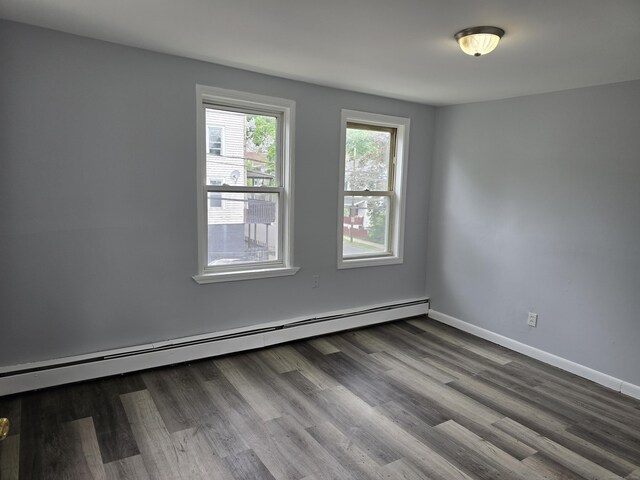 78 Tremont St, New Britain, CT 06051 - spare room featuring a baseboard heating unit, baseboards, and dark wood-type flooring